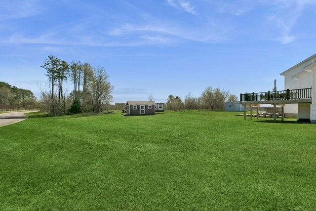 23892 187th St NW, Big Lake, MN 55309 - view of grassy yard with a deck, an outbuilding, and a storage shed