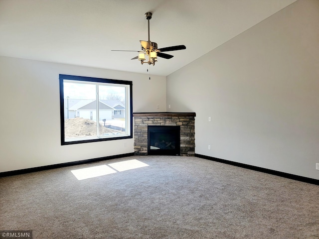 unfurnished living room featuring a stone fireplace, carpet, ceiling fan, and lofted ceiling