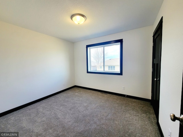 carpeted empty room with baseboards and visible vents