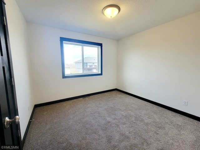 carpeted empty room with baseboards