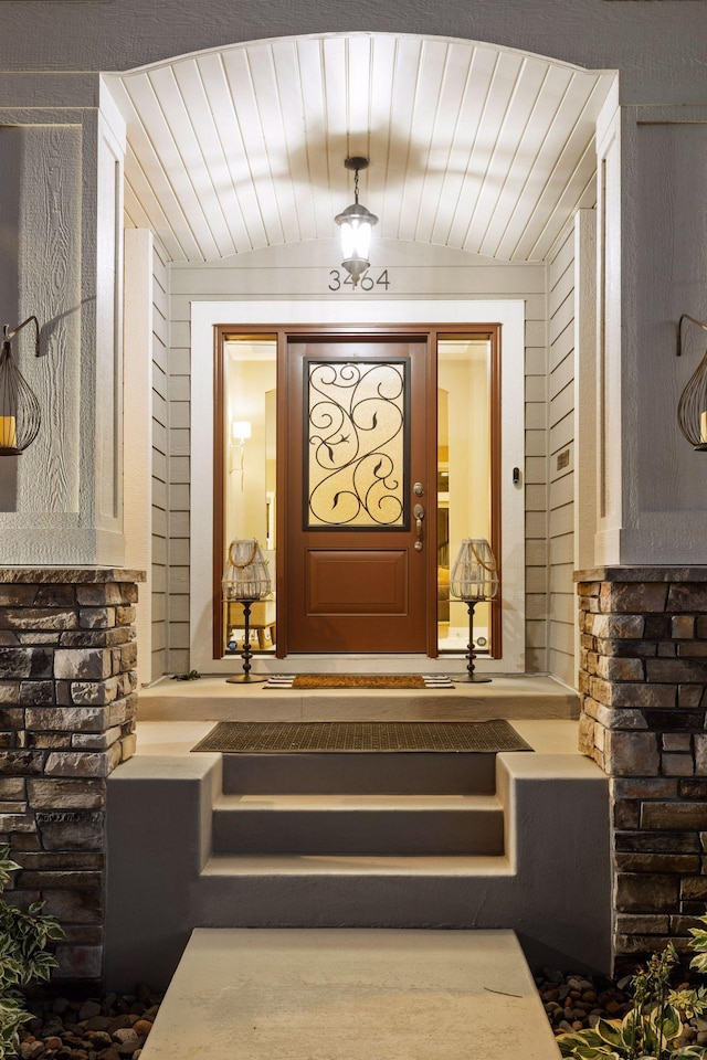 doorway to property featuring stone siding