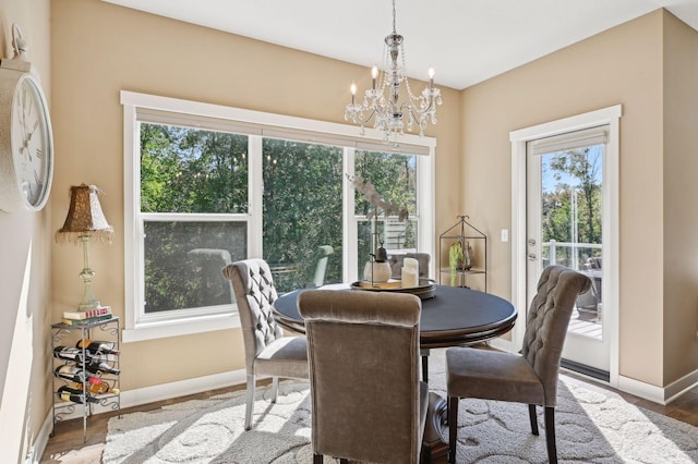 dining area featuring baseboards, a notable chandelier, wood finished floors, and a wealth of natural light