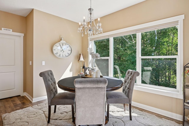 dining space with baseboards, wood finished floors, a notable chandelier, and visible vents