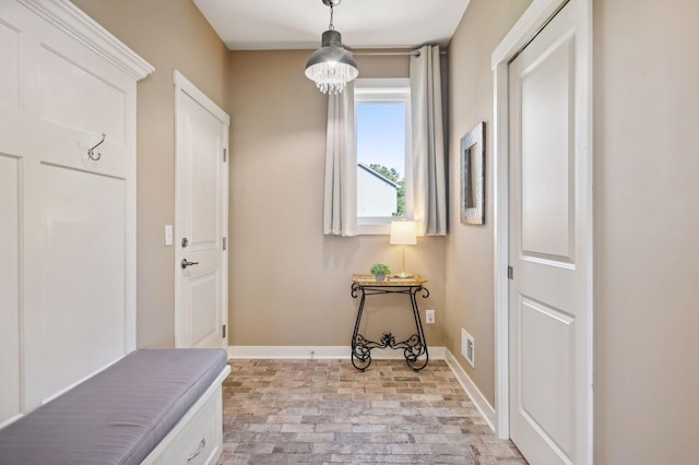 mudroom with baseboards, brick floor, and visible vents