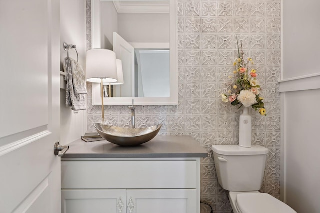 bathroom featuring crown molding, toilet, and vanity