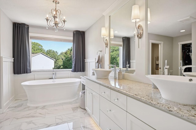 full bathroom featuring a healthy amount of sunlight, a wainscoted wall, double vanity, and a sink