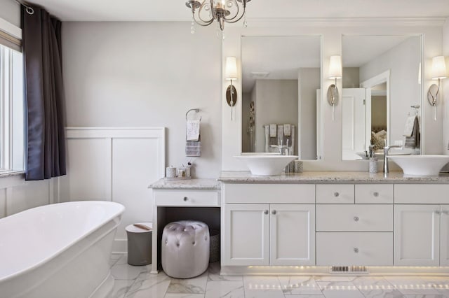 full bath with double vanity, visible vents, a freestanding tub, a sink, and marble finish floor