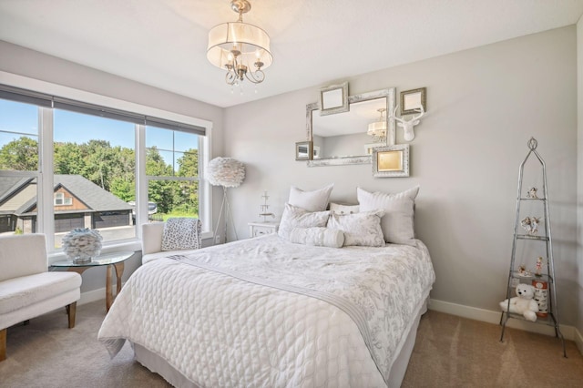 carpeted bedroom with baseboards and a chandelier