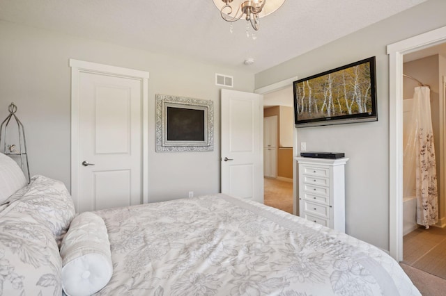 bedroom with baseboards, wood finished floors, and visible vents