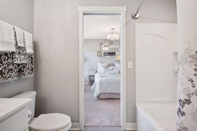 ensuite bathroom with connected bathroom, toilet, shower / washtub combination, and vanity