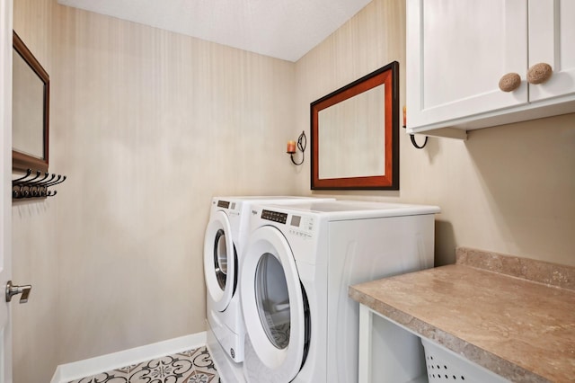 laundry room featuring separate washer and dryer, cabinet space, and baseboards