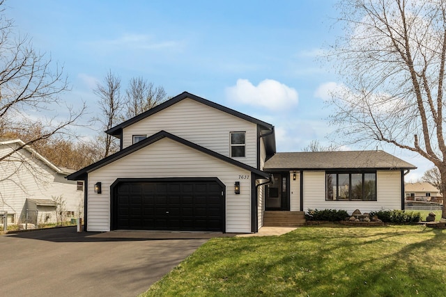 split level home featuring a shingled roof, a front yard, and aphalt driveway