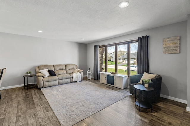 living area featuring baseboards, a textured ceiling, recessed lighting, and wood finished floors