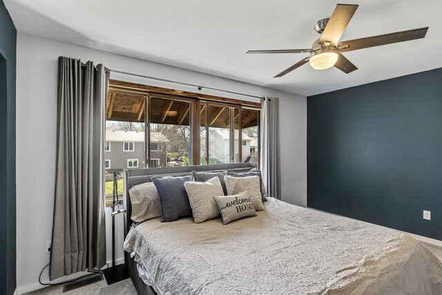 carpeted bedroom with baseboards, ceiling fan, and visible vents