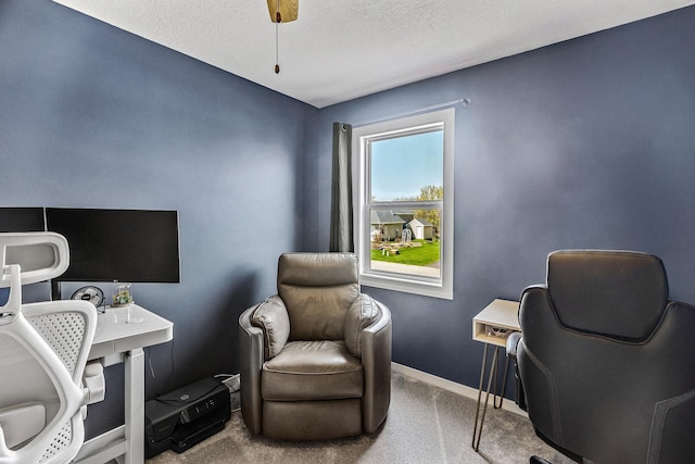carpeted office space featuring baseboards and a textured ceiling