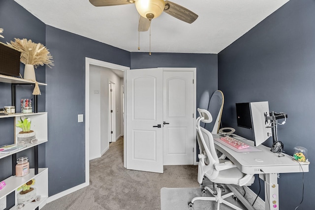 home office with carpet floors, ceiling fan, and baseboards