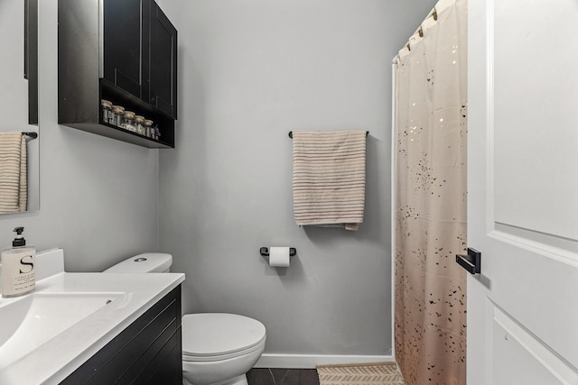 bathroom featuring vanity, toilet, baseboards, a shower with shower curtain, and tile patterned floors