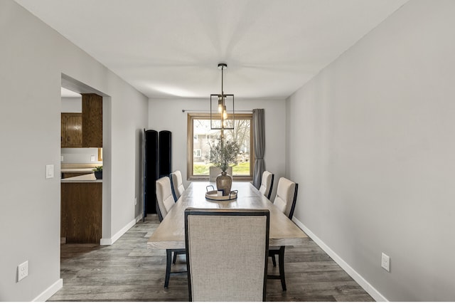 dining room featuring dark wood-type flooring and baseboards
