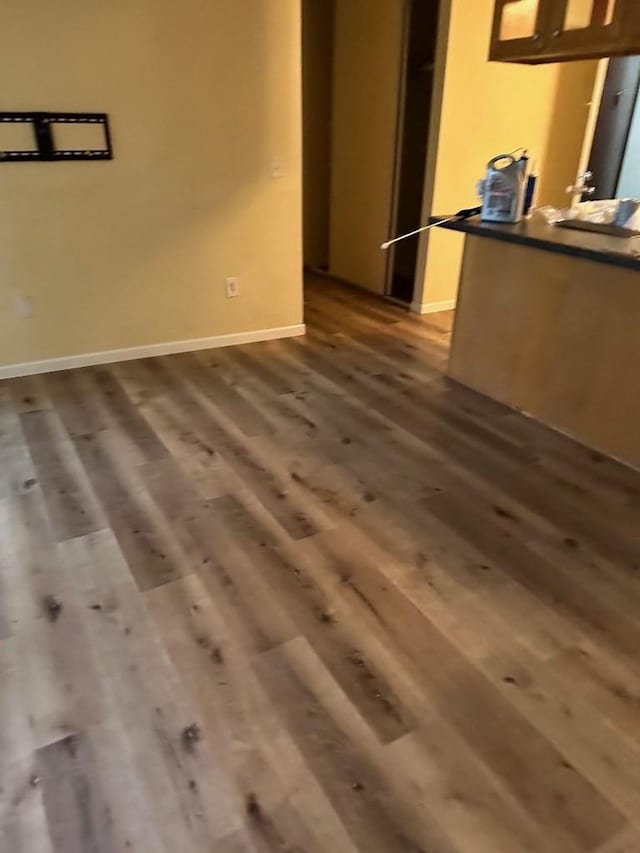 interior space featuring baseboards and dark wood-style floors