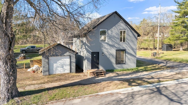 313 3rd St, Bovey, MN 55709 - view of front of property with fence, an outbuilding, a garage, and driveway