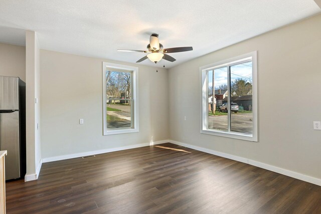 313 3rd St, Bovey, MN 55709 - unfurnished room with healthy amount of natural light, dark wood-type flooring, ceiling fan, and baseboards