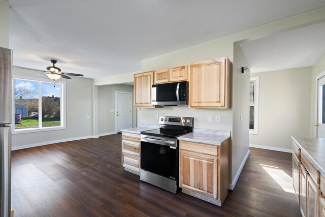 313 3rd St, Bovey, MN 55709 - kitchen featuring stainless steel appliances, light brown cabinetry, light countertops, and dark wood-style flooring
