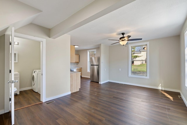 313 3rd St, Bovey, MN 55709 - unfurnished living room with separate washer and dryer, ceiling fan, dark wood-type flooring, baseboards, and lofted ceiling