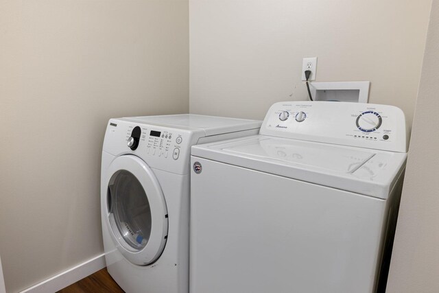 313 3rd St, Bovey, MN 55709 - laundry room featuring washer and clothes dryer, dark wood-type flooring, and baseboards