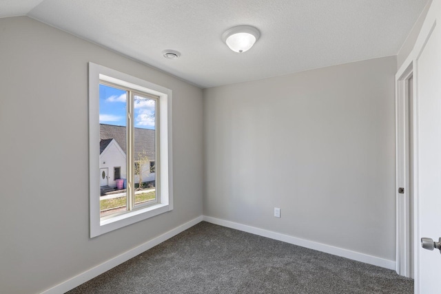 313 3rd St, Bovey, MN 55709 - unfurnished room featuring dark colored carpet, baseboards, and a textured ceiling