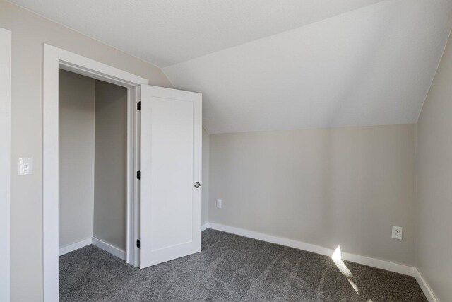 313 3rd St, Bovey, MN 55709 - additional living space with dark carpet, lofted ceiling, and baseboards