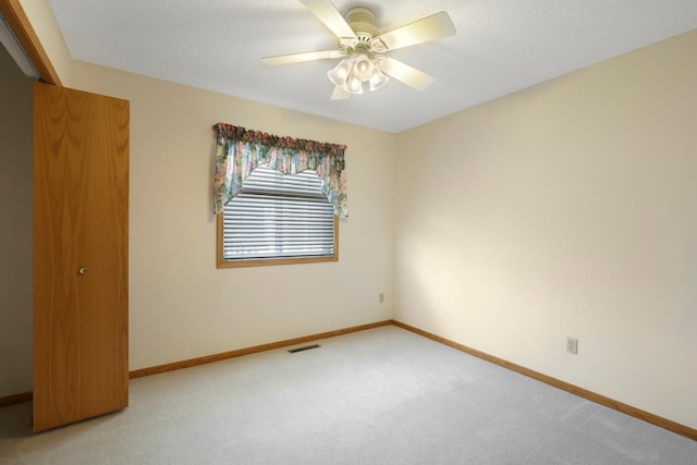 spare room featuring baseboards, light carpet, and visible vents