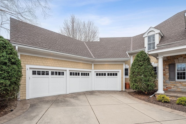 view of front of house with concrete driveway, an attached garage, and roof with shingles