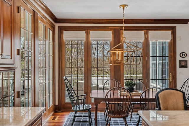 dining space with crown molding, baseboards, and wood finished floors