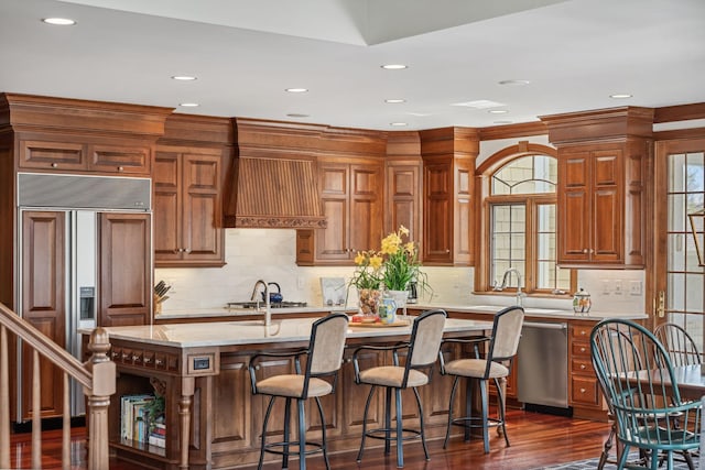kitchen with recessed lighting, an island with sink, a kitchen breakfast bar, and stainless steel appliances