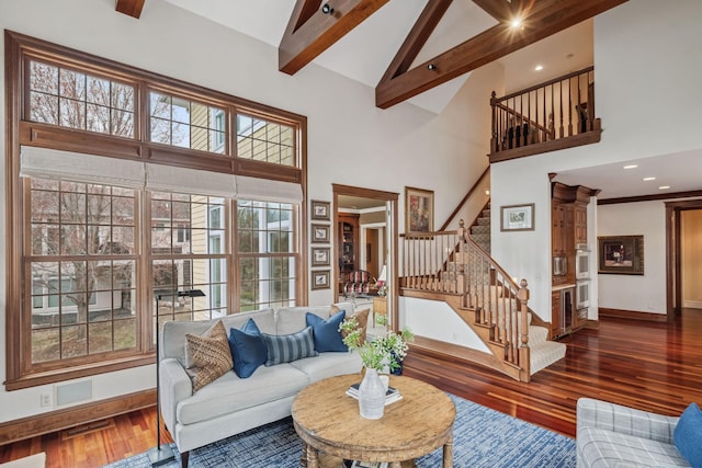 living room with beam ceiling, high vaulted ceiling, baseboards, wood finished floors, and stairway