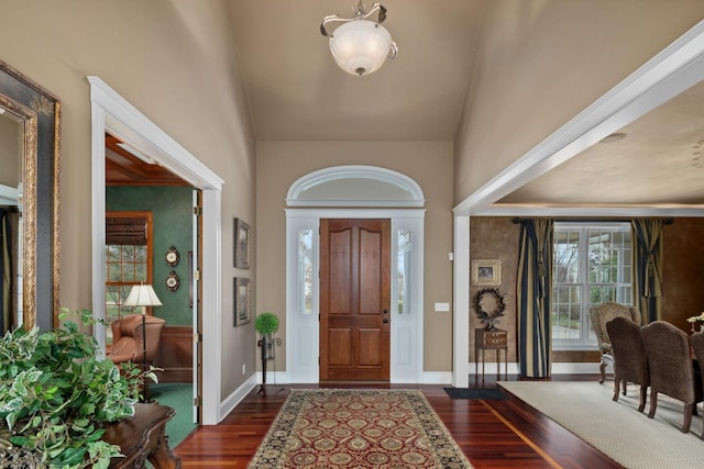 entrance foyer featuring high vaulted ceiling, baseboards, and dark wood-type flooring