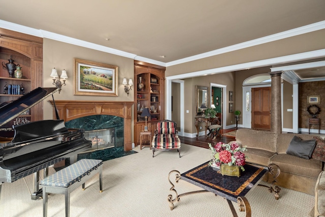 living room featuring crown molding, decorative columns, built in features, baseboards, and a premium fireplace