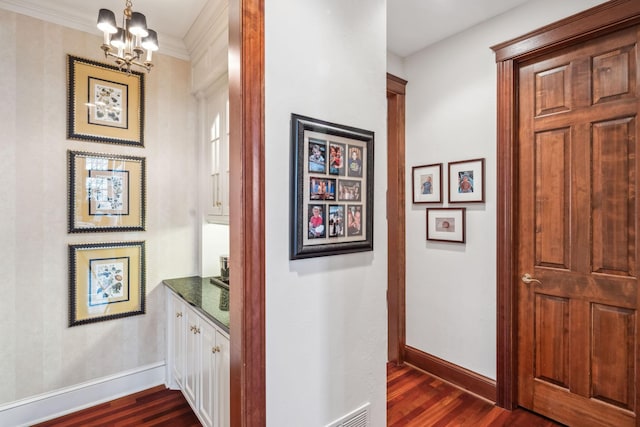 hall with baseboards, dark wood finished floors, and an inviting chandelier
