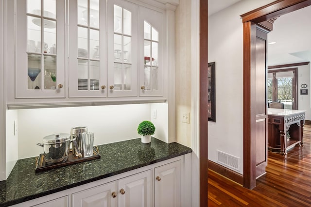 bar with baseboards, dark wood finished floors, and visible vents
