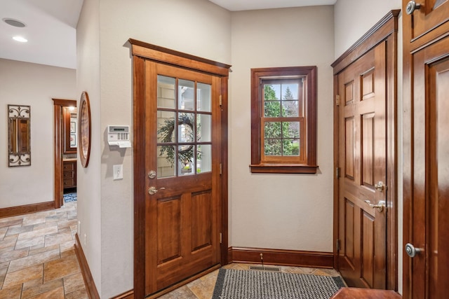 entryway featuring recessed lighting, baseboards, and stone finish flooring