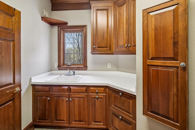 kitchen with a sink, brown cabinets, and light countertops