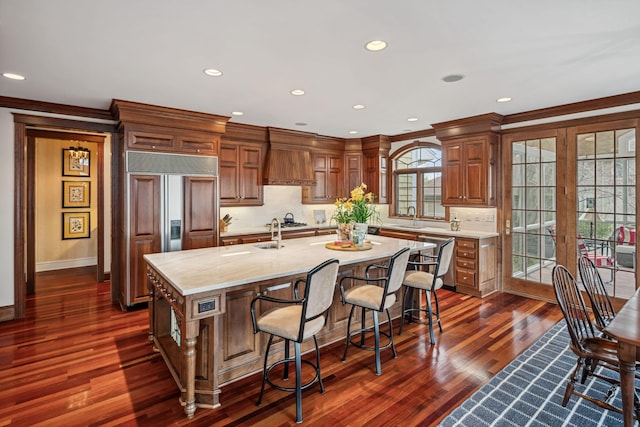 18371 Bearpath Trl, Eden Prairie, MN 55347 - kitchen with paneled fridge, a sink, a kitchen island with sink, decorative backsplash, and dark wood-style floors