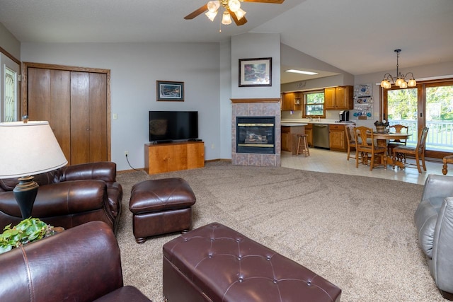 living room with vaulted ceiling, ceiling fan, a chandelier, a fireplace, and baseboards