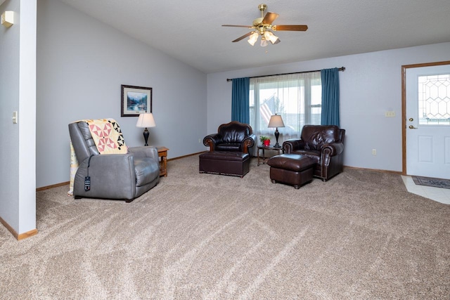 living room with a ceiling fan, healthy amount of natural light, carpet floors, and lofted ceiling