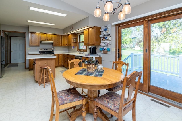 dining area with light flooring and a chandelier
