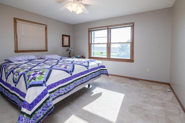 carpeted bedroom with baseboards and a ceiling fan