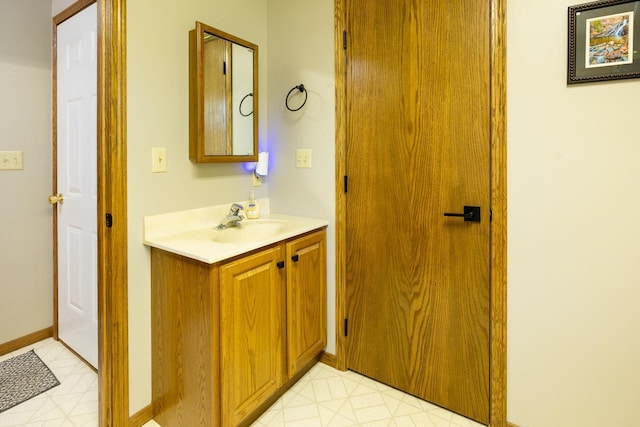 bathroom with vanity, baseboards, and tile patterned floors