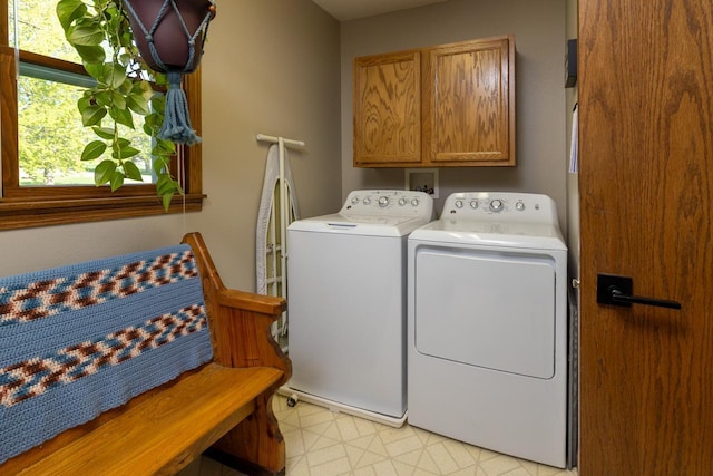 laundry area featuring washing machine and clothes dryer, cabinet space, and light floors