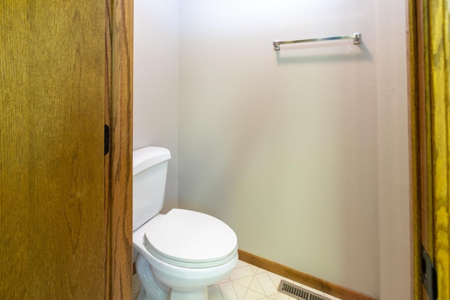 bathroom with toilet and baseboards
