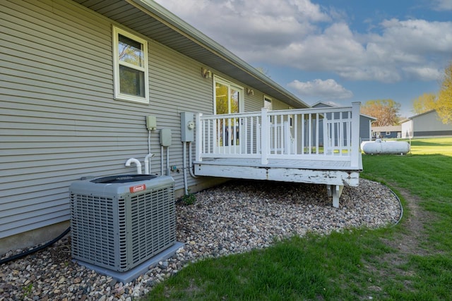 view of property exterior featuring cooling unit, a wooden deck, and a yard